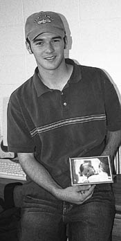 Brent Webster holds up one of the few knick knacks gracing his West Hall dorm room, a baby picture of himself.