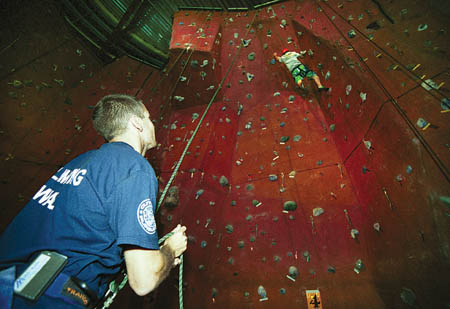 Student Life Center climbing wall supervisor Josh Kling belays during Fear Factor contestant Doug Lamdells' three minutes on the wall.