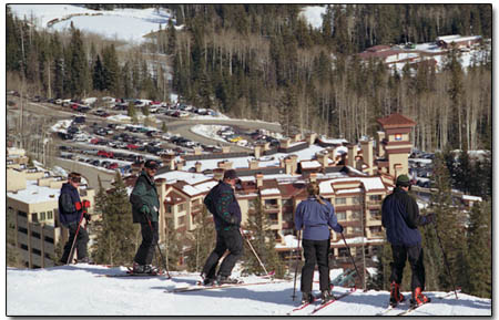 A group of skiers stop to take in the view from the top of the Demon headwall.