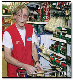 Richard Curtis, a K-Mart employee, restocks shelves after the first wave of holiday shoppers arrived.