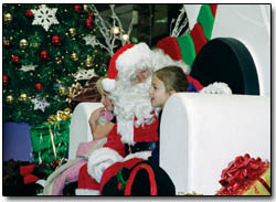 Madeline Robertson, 4, tells Santa Claus exactly what she wants for Christmas while her sister, Hannah, waits her turn at the Durango Mall.