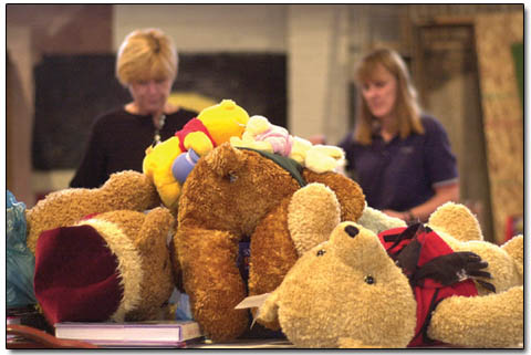Volunteer Terre Isenberger, left, and Project Merry Christmas board member Kaye Weis sort through stuffed animals in the Armory Building Monday.