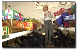 Project Merry Christmaas board member Charlotte Fischer organizes gifts for elderly recipients Saturday.