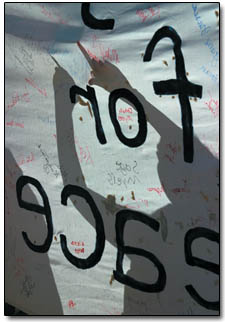 Adrian Sagan commits his name to ink and signs the banner for peace.