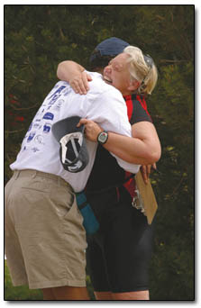 Race Director Bill Bolden gives a congratulations hug to a race participant.