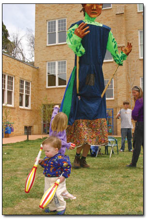 18-month-old Connor Fitzpatrick handles a pair of bowling pins in the foreground of the Earth Day celebrations.