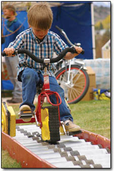 5-year-old Caleb Langford concentrates on working the square tricycle over the curved track Saturday afternoon.