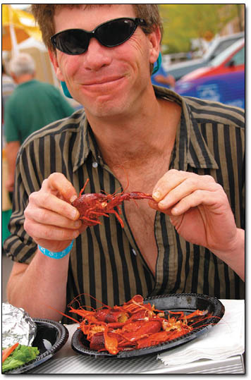 Crazy Mike, of Durango, enjoys a plate of crawfish right before the rain hits.