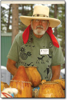 Rob Wilson, of Art of the Southwest, shelters his gourds from a few drops of rain.