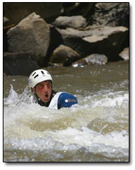 After a courageous attempt at whitewater canoeing, a swimmer takes a breath before heading downstream.