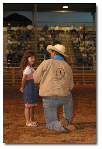 Corinne McNamara graciously accepts her first place prize inthe Mutton Bustin' competition.