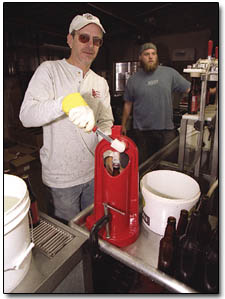 Doing it the old-fashioned way: Durango Brewing's Nick Meyer, left, and Paul Wright, right, fill the bottles...then cap them.  Then you drink them.