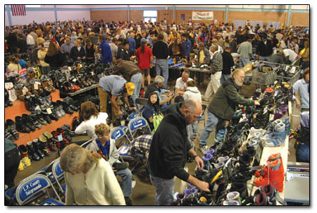 The early morning crowd peruses the mounds of new and used apparel at the fairgrounds on Saturday morning.