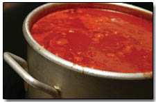 A fresh batch of sauce warms up on the stove at Homeslice Pizza.