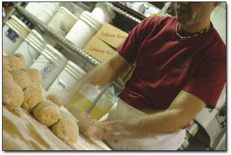 Arch works furiously to flatten a pile of dough at Carvers.