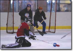 Danny Broughton, of the semi-professional broomball team the Pueblo Steel, attempts a shot on goal from his knees at the Chapman Hill Ice Rink on Saturday morning.