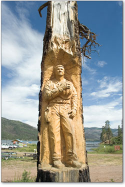 
  A wood carving dedicated to the memory of firefighter Alan Wyatt stands in front of Angler's Wharf.
