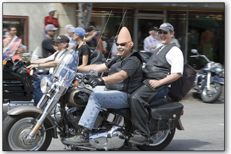 A cone head and his passenger enjoy their trip along Main Avenue as motorcyclists take over downtown Durango.