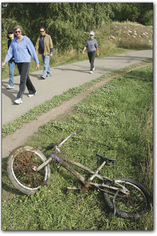 Animas River trail users check out a bicycle which was pulled from the river and awaits pick-up.