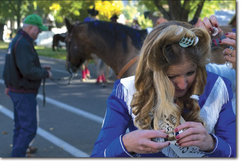 Molly Watson, the 2005 Fiesta Days Queen, pulls rollers from her hair before saddling up for the parade.