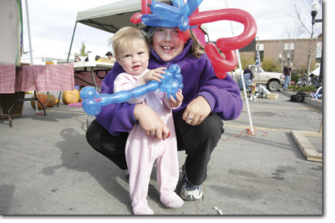 Madelyn, left, and Lizzy Napier enjoy the festivities as the last Farmers Market of the year slowly winds down.