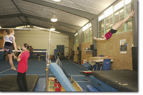 Jessi Petersen flies through the air on the vault as practice continues during a busy Monday evening at the Mason Center.