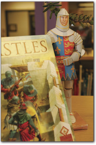 A toy knight watches over a display of books downstairs in the children's area.