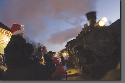 Riley Amos, 3, watches the arrival of the Polar Express from atop his father's shoulders Saturday night at the train depot.