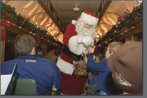 Santa Claus makes his way through the train cars of the Polar Express handing out reindeer bells to all the children.