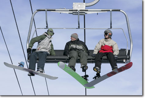 A trio of snowboarders catch a late afternoon lift up the hill at Durango Mountain Resort's opening day last Saturday.
