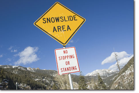 A pair of signs inform motorists of the potential dangers in the
snowpack high above the roadway on the east side of Wolf Creek
Pass.
