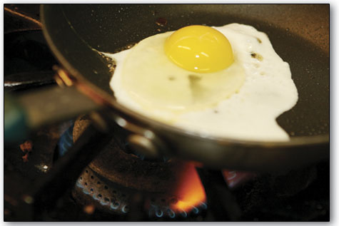 An egg sizzles in the kitchen at Oscar's on Sunday.