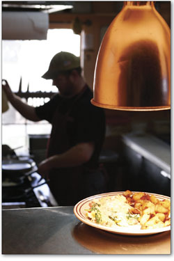 Chad Carpenter works his magic in the kitchen at the College
Drive Caf as a hot plate of food waits to be delivered.