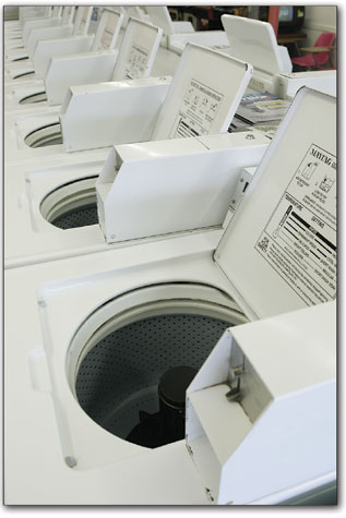 A row of washing machines sits idle on a quiet Tuesday morning
at Town Plaza Coin Laundry.