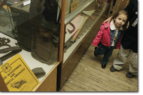 Giselle Valdez wanders past a display case of historical
memorabilia downstairs at the Animas Museum.