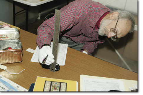 Volunteer Henry Ninde begins to catalogue a tin full of family
artifacts donated by the Franks family.