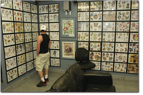 James Rossman peruses the variety of tattoos on display at Blue
Tiger Tattoo as he waits through a mid-afternoon rush of body
piercings.