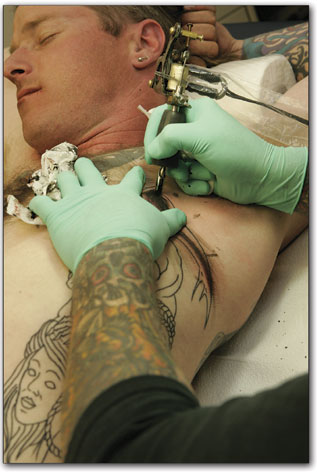Bob Lyon, of Blue Tiger Tattoo, lays down some ink on the very
sensitive rib cage of Scott Cornett.