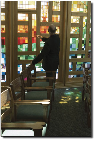 Staff Chaplin Ken Downey examines the stained glass work of
Betty Kilpatrick from inside the chapel.