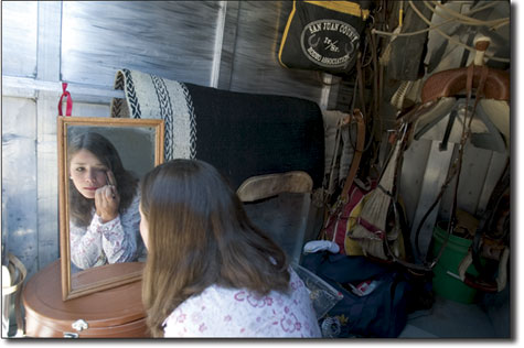 Casey Luzar freshens up in the storage compartment of her horse
trailer.