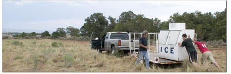 Thomas Vanderleest, Danny Breed and Chris Breed load an ice box
onto a trailer. The box was used by a hotshot crew fighting fires
on Red Mesa recently.