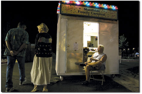 Pharley Adams and his dog Jessie James share a cigar outside the  carnivals ticket booth.