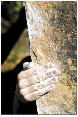 A climbers hand appears at the top of a boulder problem near
Turtle Lake.