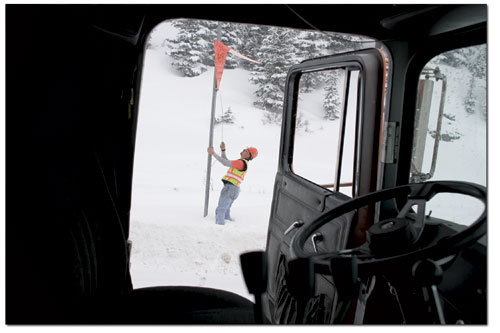 CDOT plow driver Dak Klein pulls the cord on a sign signaling
travelers to expect heavy machinery on the road ahead.