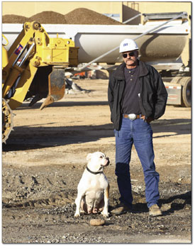 Jim Cherry, who operates an excavator, and his dog Sadie watch
as a base layer is spread across the nearly vacant lot. This will
allow new structures to be erected on solid earth.