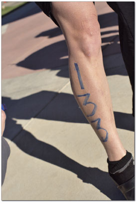 Athletes get their numbers painted on pre-race in order to make
themselves more visible to race officials. Here, Mari Rice gets a
lucky 133 tattooed down her leg.