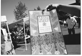Maggie Fuller spreads the love and posters around the Farmers
Market on Saturday.