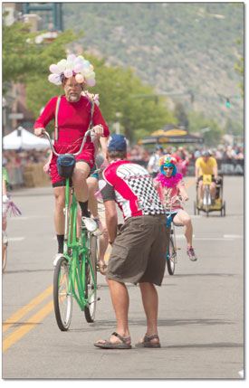 Russell Zimmermann, owner of Durango Cyclery and head of the
Smiley Bike Project, prepares to help the winner of the Cruiser
Crit dismount after the race.