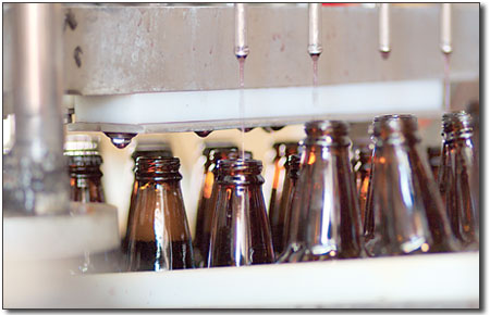 Here, a batch of grape soda gets filled and capped.