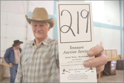 Durango native Gene Folsom holds up his bid card during the
final hours of the weekend-long auction held at the La Plata County
Fairgrounds.a
